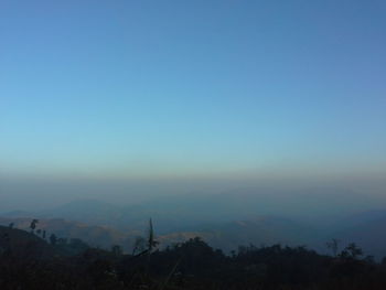 Scenic view of silhouette mountains against clear sky at sunset