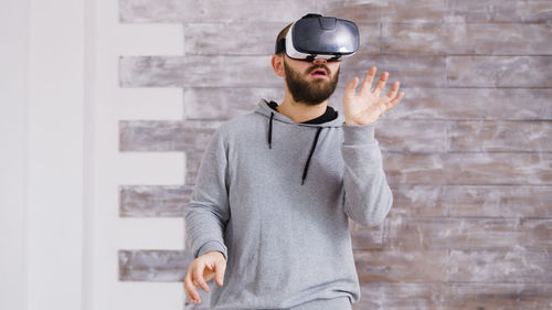 Young man wearing sunglasses while standing against wall