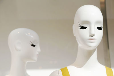 Close-up of mannequins seen through store window