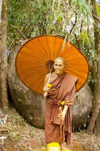 Woman standing on tree trunk