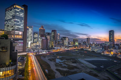 Illuminated cityscape against sky at night