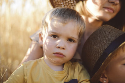 Portrait of cute boy with mother and brother on field