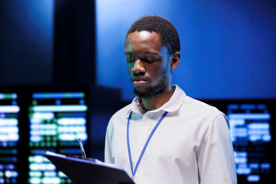 Side view of young man using laptop at home