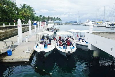 Boats moored on shore against sky