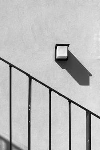 Shadow on railing against wall