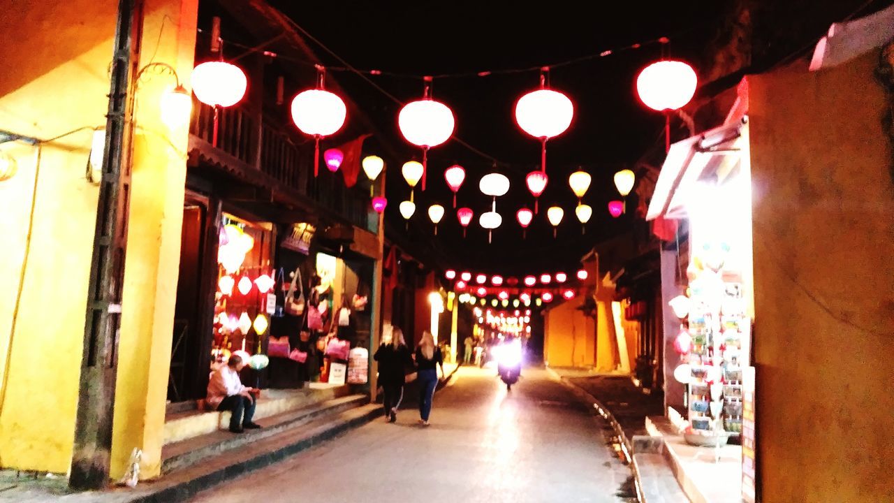 architecture, illuminated, built structure, arch, lighting equipment, the way forward, indoors, men, walking, person, night, building exterior, ceiling, incidental people, lantern, place of worship, hanging, religion, architectural column