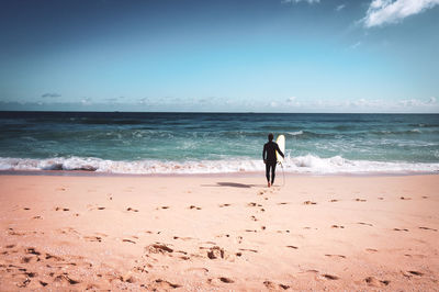 Full length of woman on beach against sky