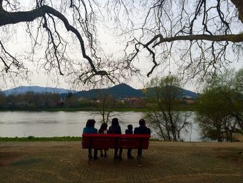 People relaxing on lakeshore