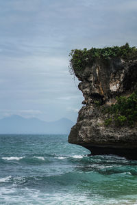 Rock formation on sea against sky