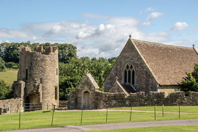 Historic building on field against cloudy sky