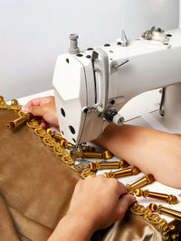 Cropped hand of woman working on sewing machine