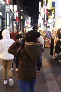 Rear view of people walking on street