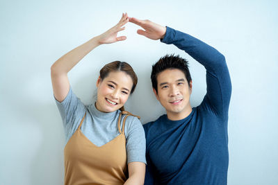 Portrait of happy friends against white background