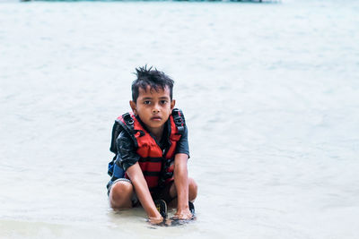 Portrait of young woman standing at beach
