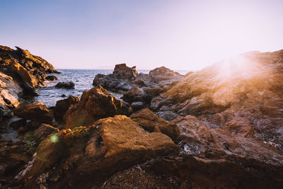 Scenic view of rocks in sea against clear sky