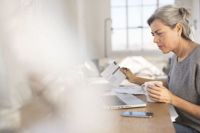 Concentrated woman working in at table in home office