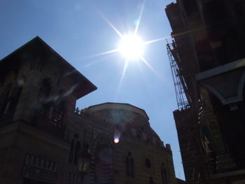 Low angle view of illuminated buildings against sky on sunny day