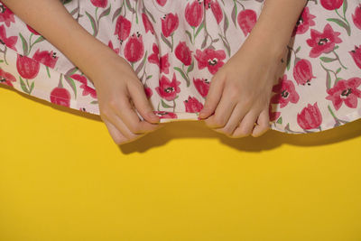 Low section of woman lying on yellow floor