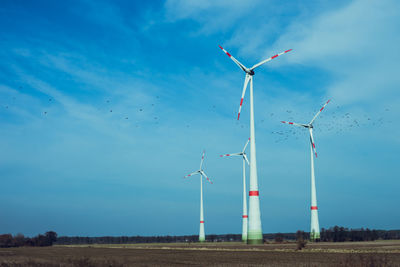 Low angle view of windmill on field against sky