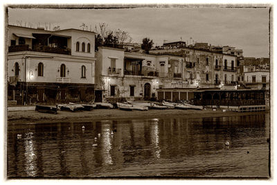 Boats in river with buildings in background