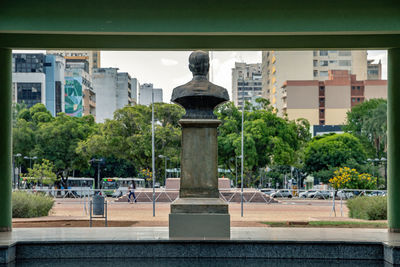 Statue by historic building against sky in city