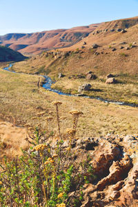 Scenic view of land and mountains against sky