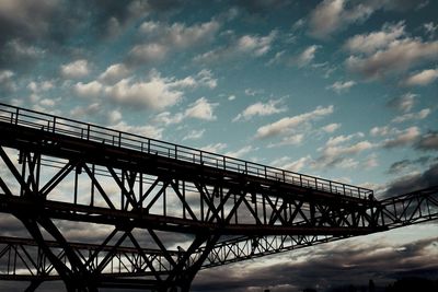 Low angle view of bridge against cloudy sky