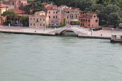 Bridge over river by buildings in city