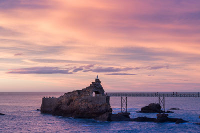 Lighthouse at seaside during sunset