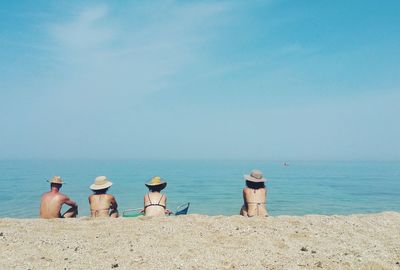 Rear view of people overlooking calm sea