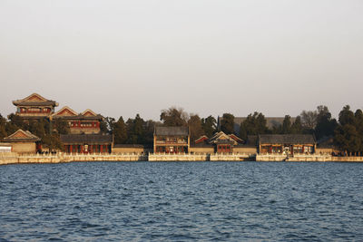 Scenic view of lake by building against clear sky