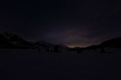 Scenic view of snow covered mountains against sky at night