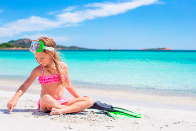 Full length of woman sitting on beach