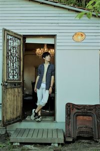 Full length of man standing at entrance of building