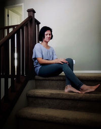 Portrait of young woman sitting on staircase