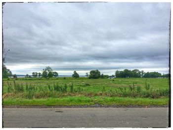 Scenic view of field against cloudy sky