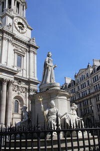 Statue of queen anne at outside the west front of st paul's cathedral in sunny day, london, uk