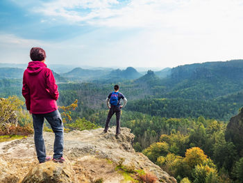 Boy and girl tourists stay on cliff and watching the wild landscape. dreamy natural landscape