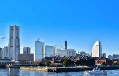 Modern buildings in city against clear blue sky