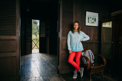 Portrait of smiling woman standing outside house