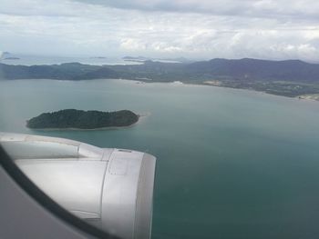 Close-up of airplane wing over sea against sky