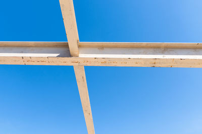 Low angle view of wooden structure against blue sky