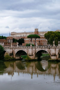 Arch bridge over river against sky