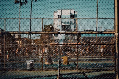 Chainlink fence in cage against sky