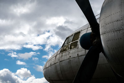 Low angle view of airplane against cloudy sky