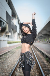 Young woman standing on railroad track