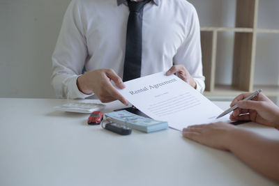 Midsection of couple holding hands on table