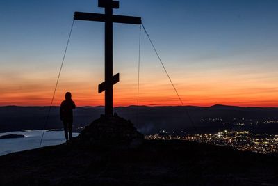 Silhouette man standing on mountain against sky during sunset