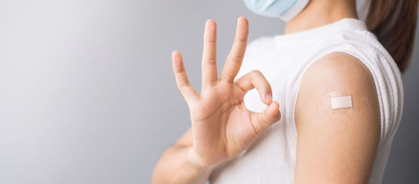 Close-up of woman holding hands over white background