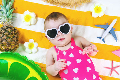 Portrait of young woman wearing sunglasses while standing against christmas tree